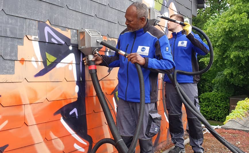 Spezialisierte Fachkräfte der PUR Graffitientfernung entfernen Graffiti mit dem Vakuumstrahlverfahren 
